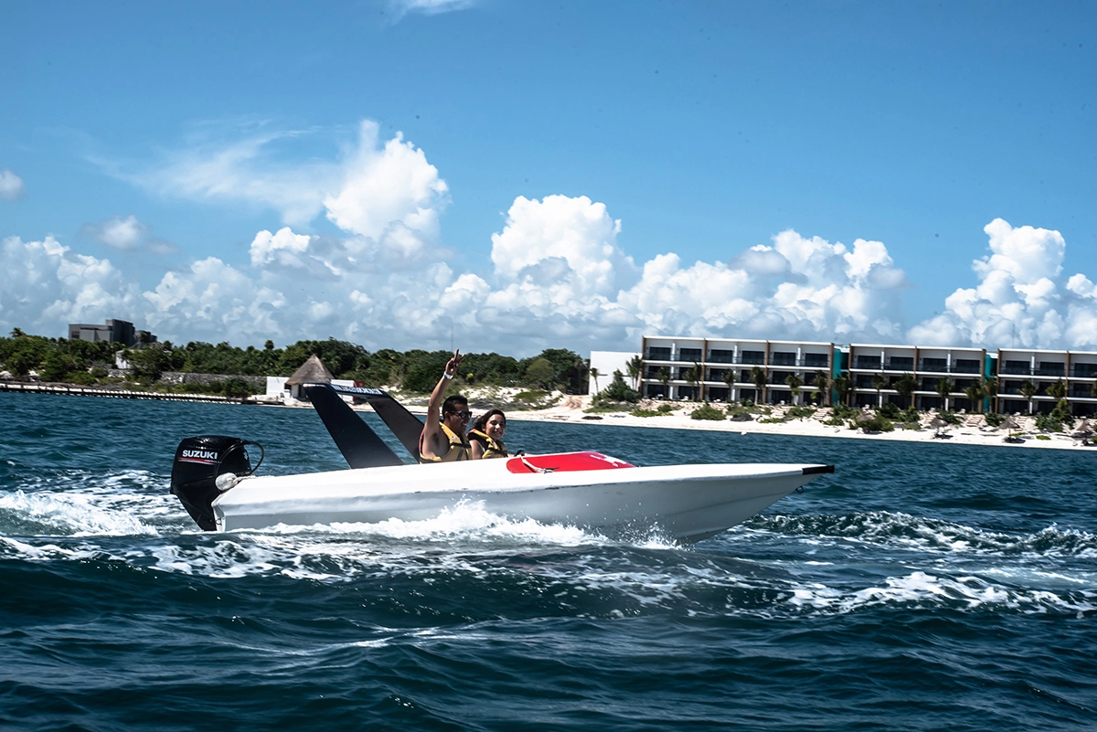 Couple riding a speedboat near Punta Nizuc reef in Cancun