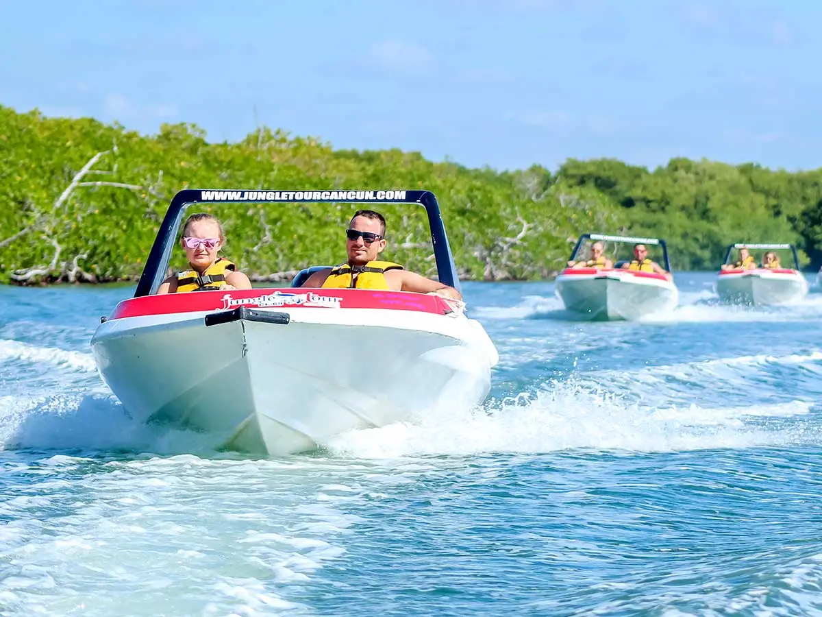 A young man driving a speedboat through the mangrove canals